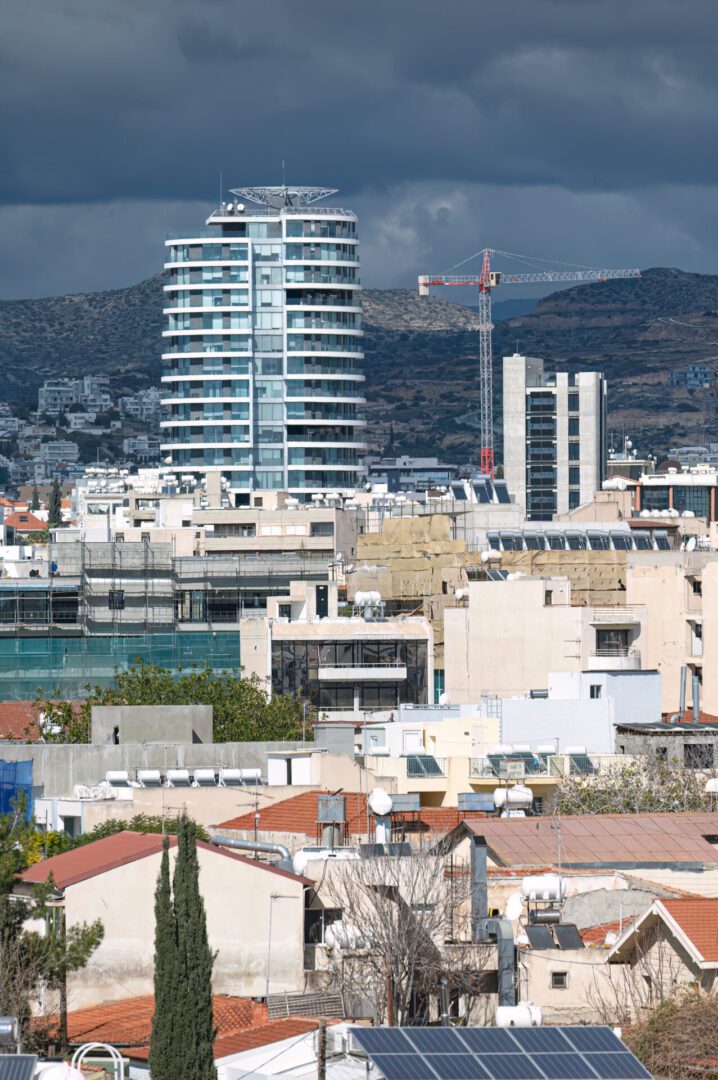 Urban cityscape with modern and older buildings under a cloudy sky.